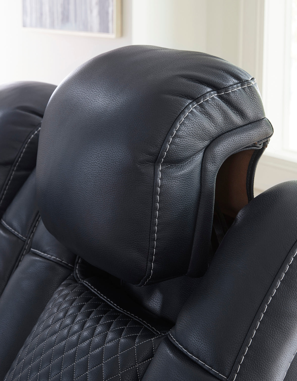 Black reclining headrest with stitched seams and padded arm