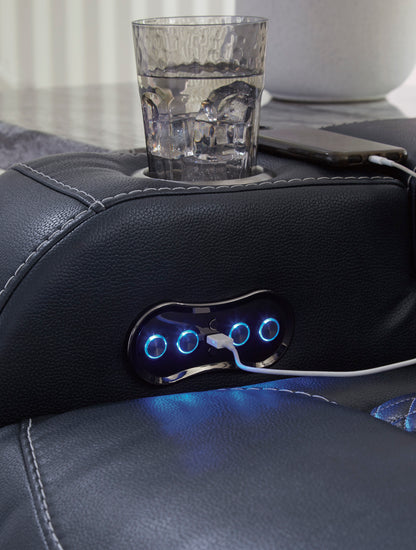 Black armrest console with two blue-lit buttons and cup holder