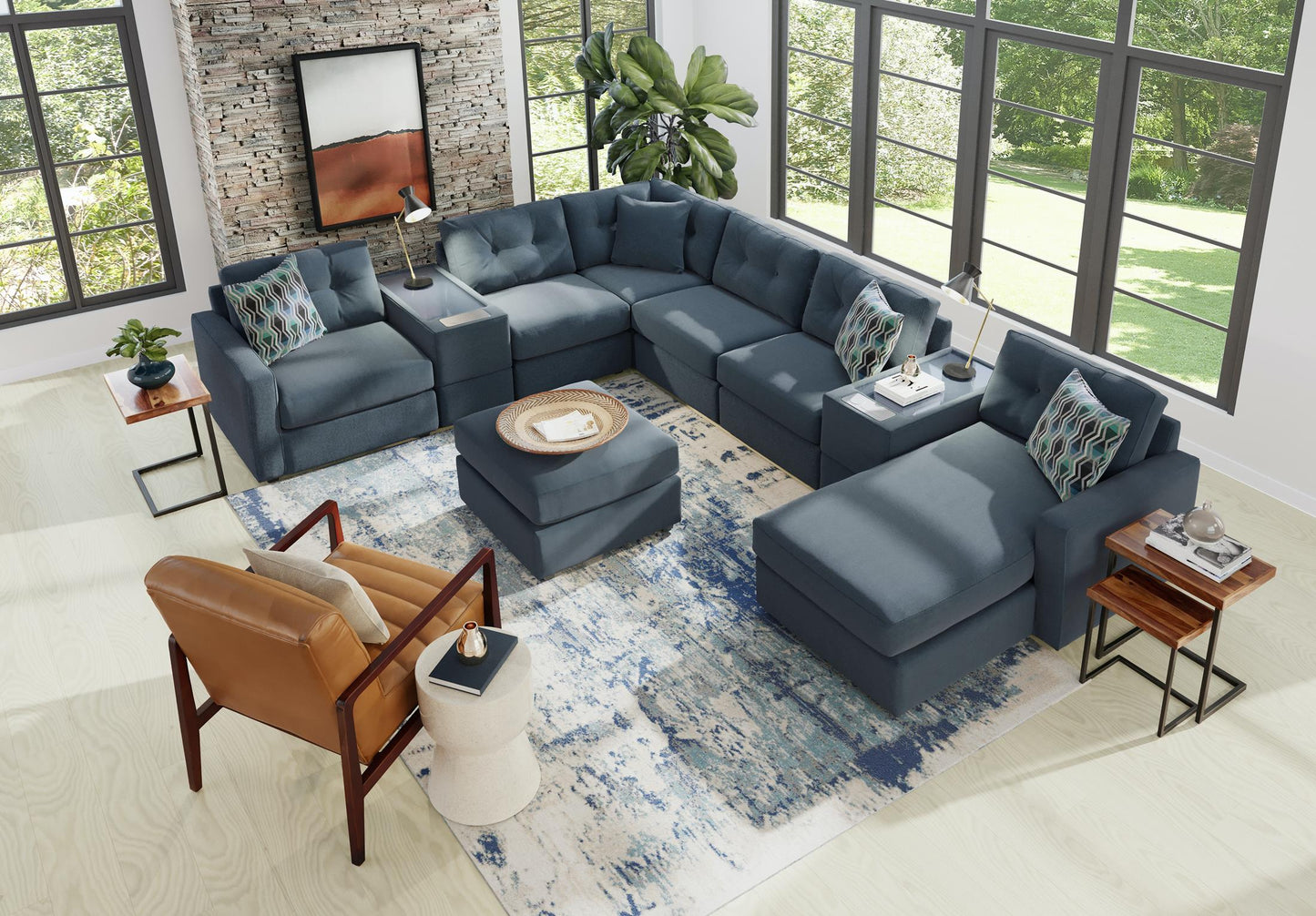 Blue-gray modular sectional sofa with patterned pillows and corner chaise ottoman seating