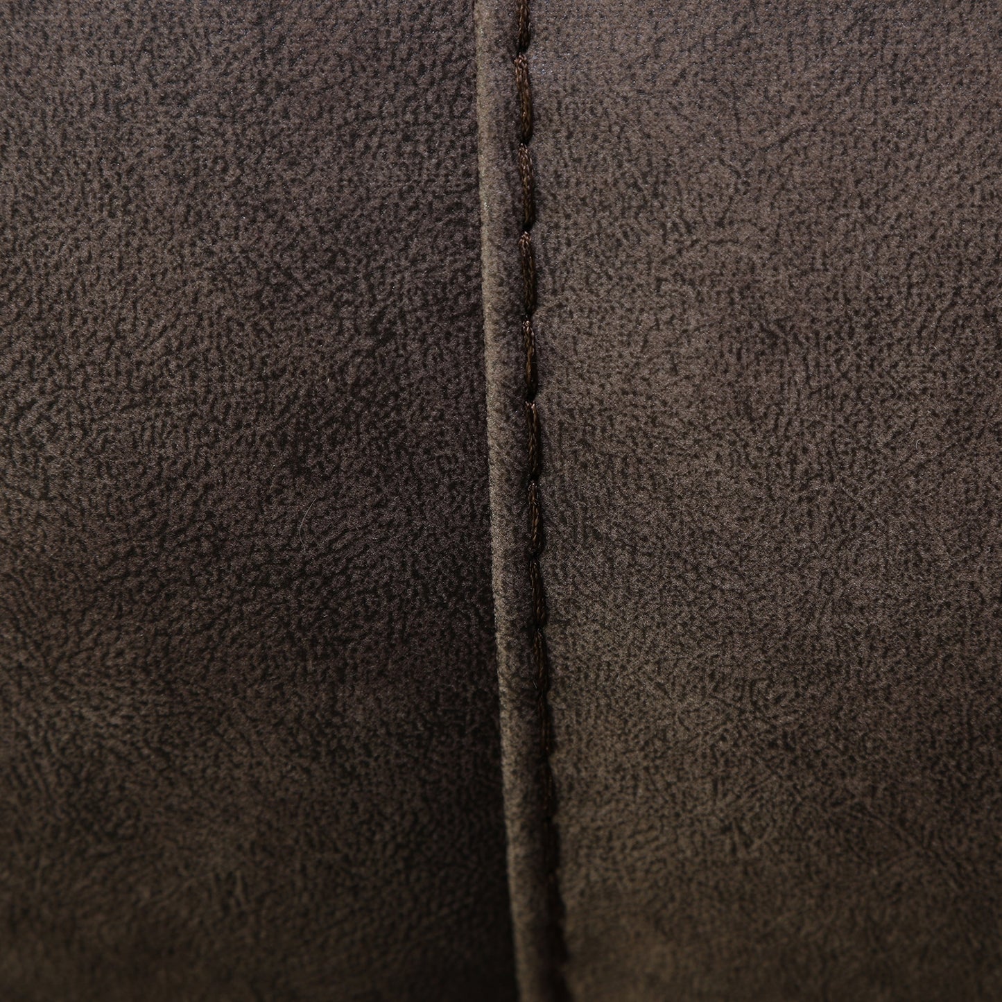 Wall-hugging power recliner side seam close-up with dark brown faux leather stitching