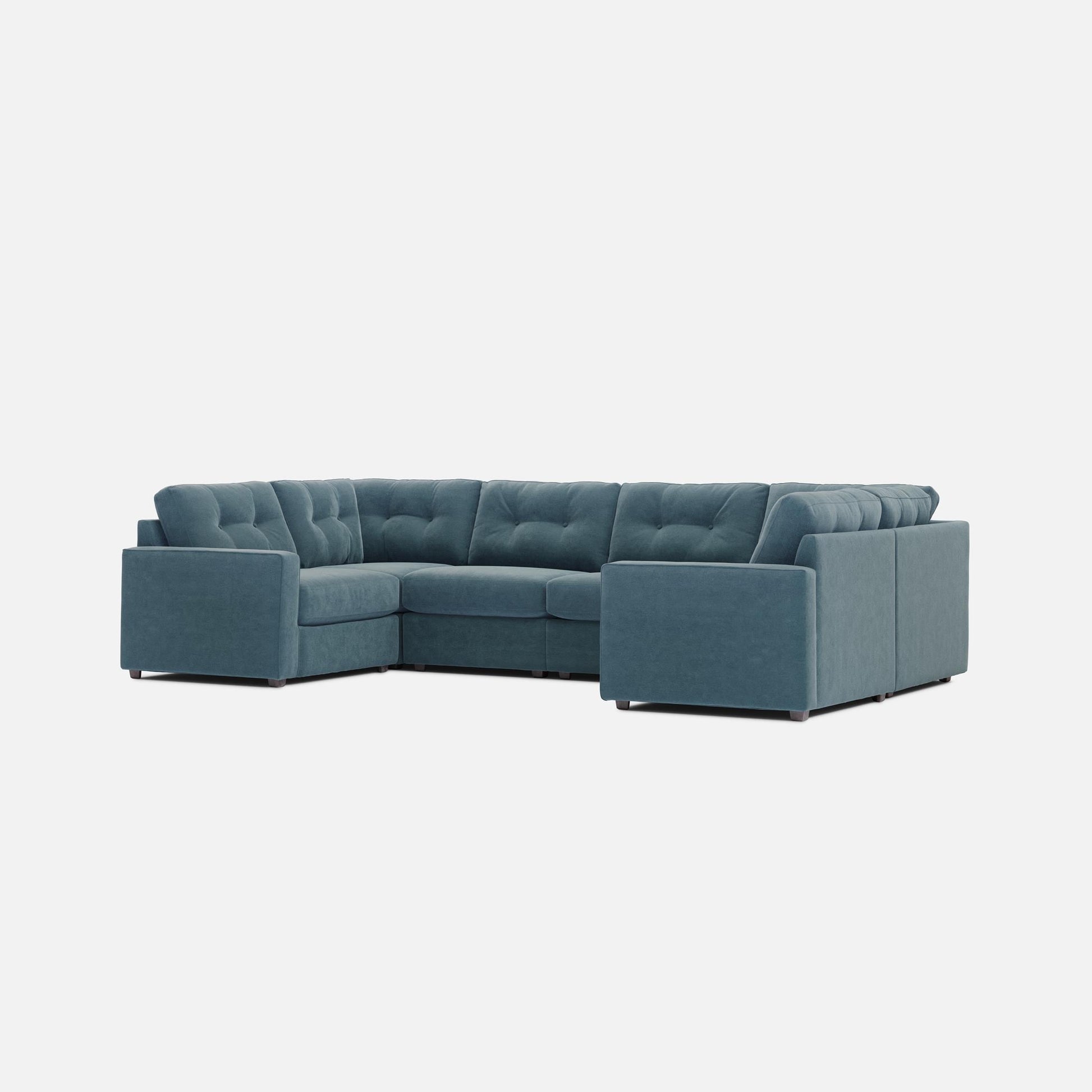 Teal modular sectional sofa with tufted back cushions and boxy corner chaise sections