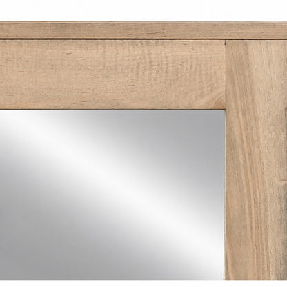 Close-up of light wood mirror frame with top rail and smooth beveled glass edge