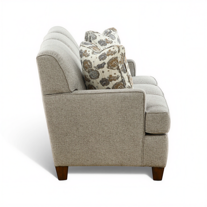 Beige sofa with two seat cushions and patterned back throw pillow