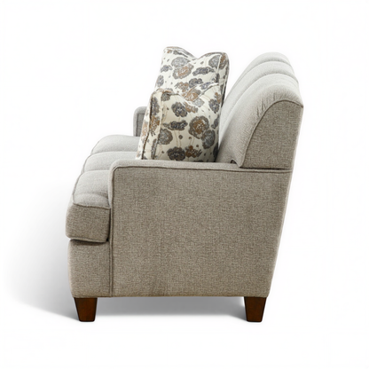 Beige sofa with rolled arms and patterned accent throw pillow