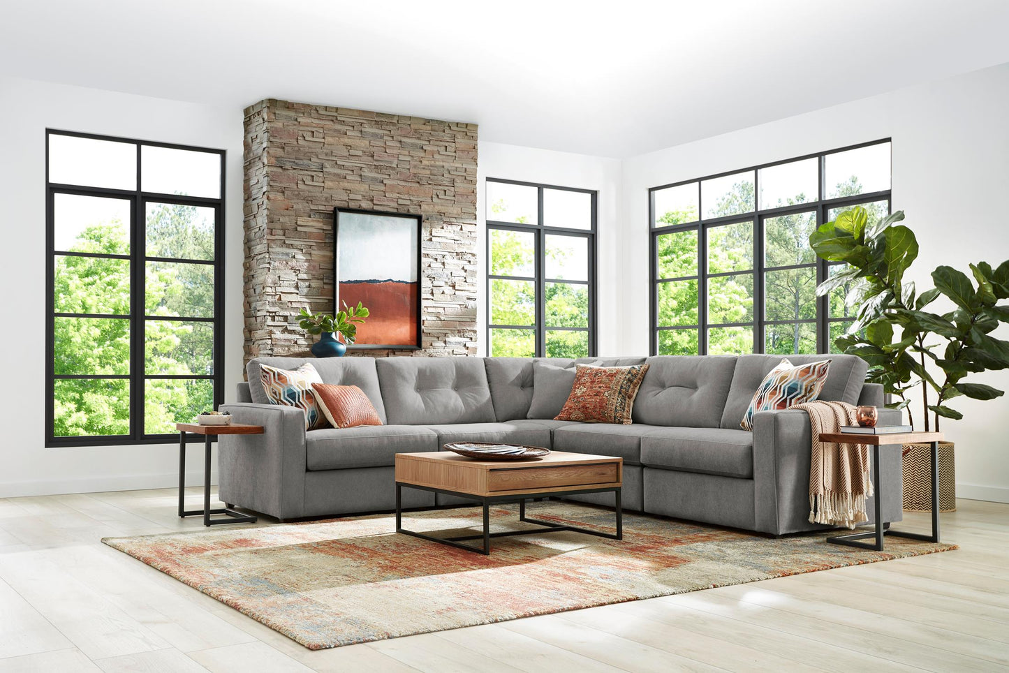 Gray modular sectional sofa with patterned throw pillows and wide chaise section