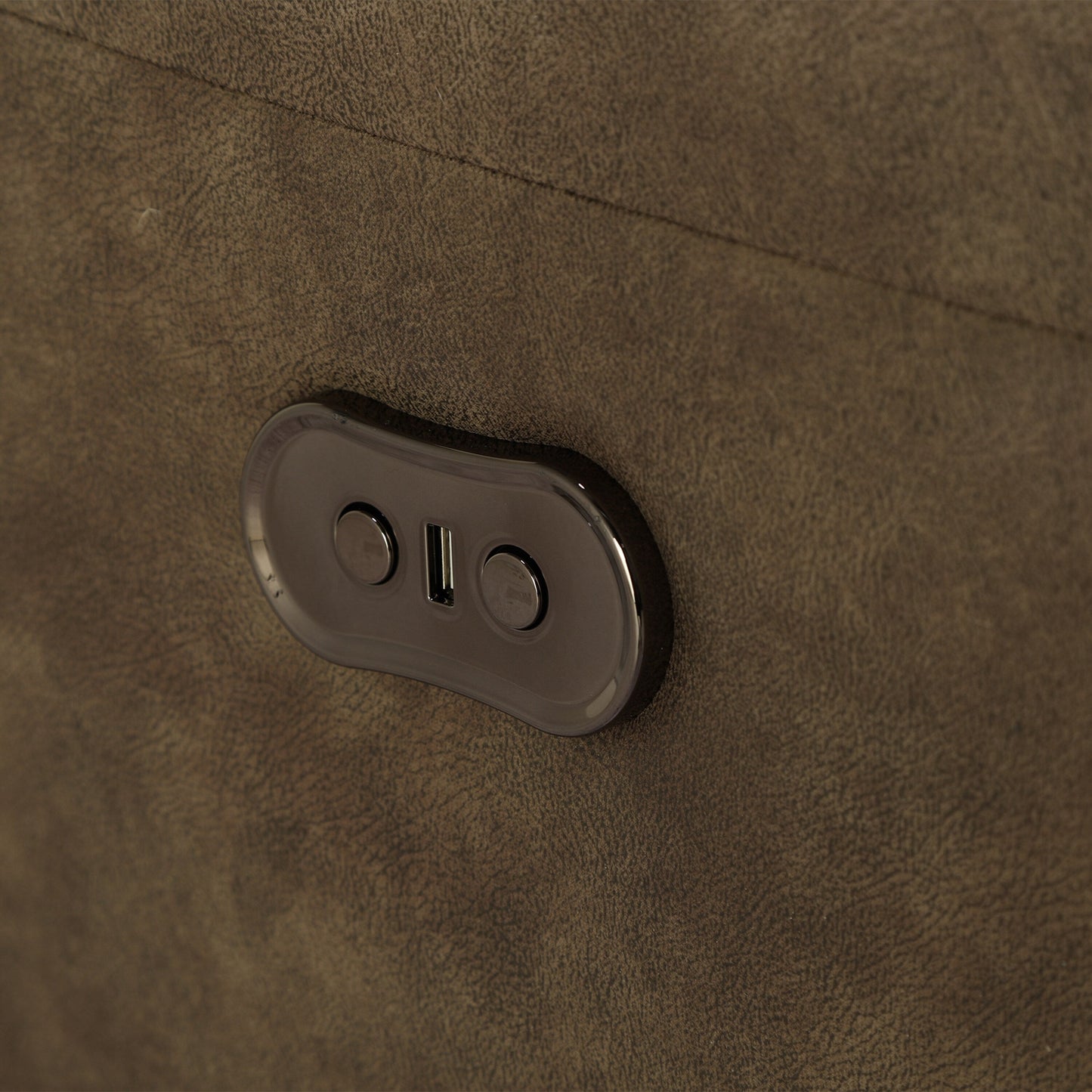 Close-up of brown sofa power control panel with button and toggle switch.