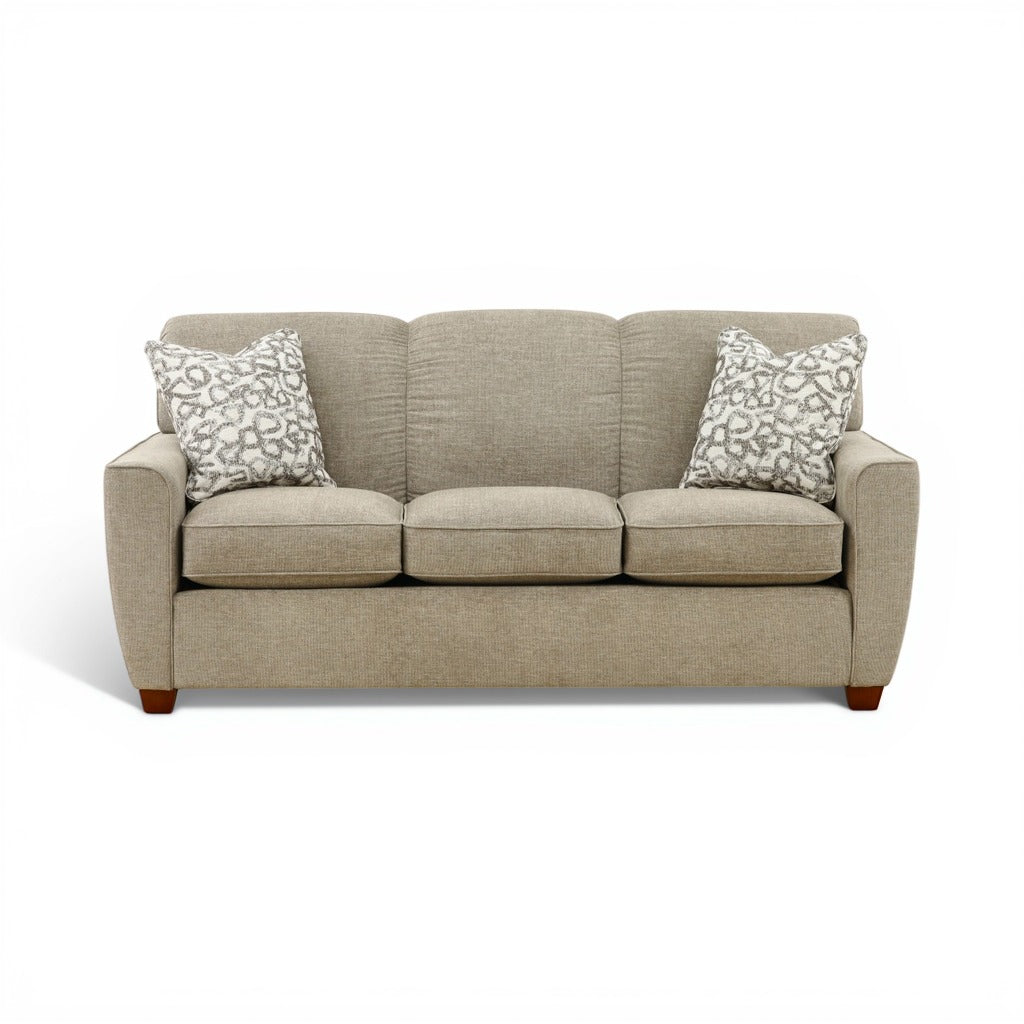 Beige fabric sofa with three seat cushions and patterned throw pillows, wooden feet