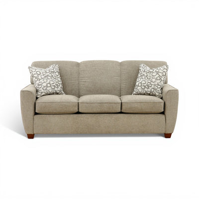 Beige fabric sofa with three seat cushions and patterned throw pillows, wooden feet