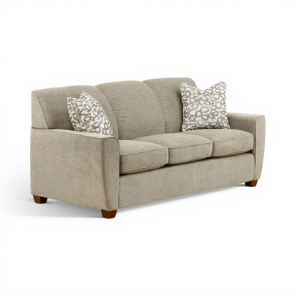 Beige two-seat sofa with curved armrests and two patterned pillows, dark feet