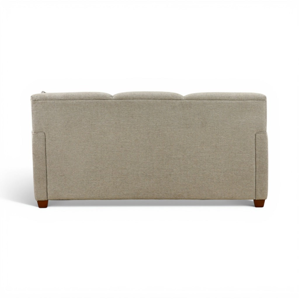 Beige upholstered sofa with boxy arms and rectangular back, exposed wooden feet