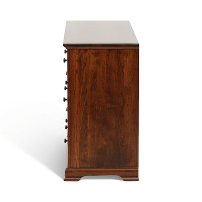 Brown wooden dresser side view with handle pulls and tapered feet