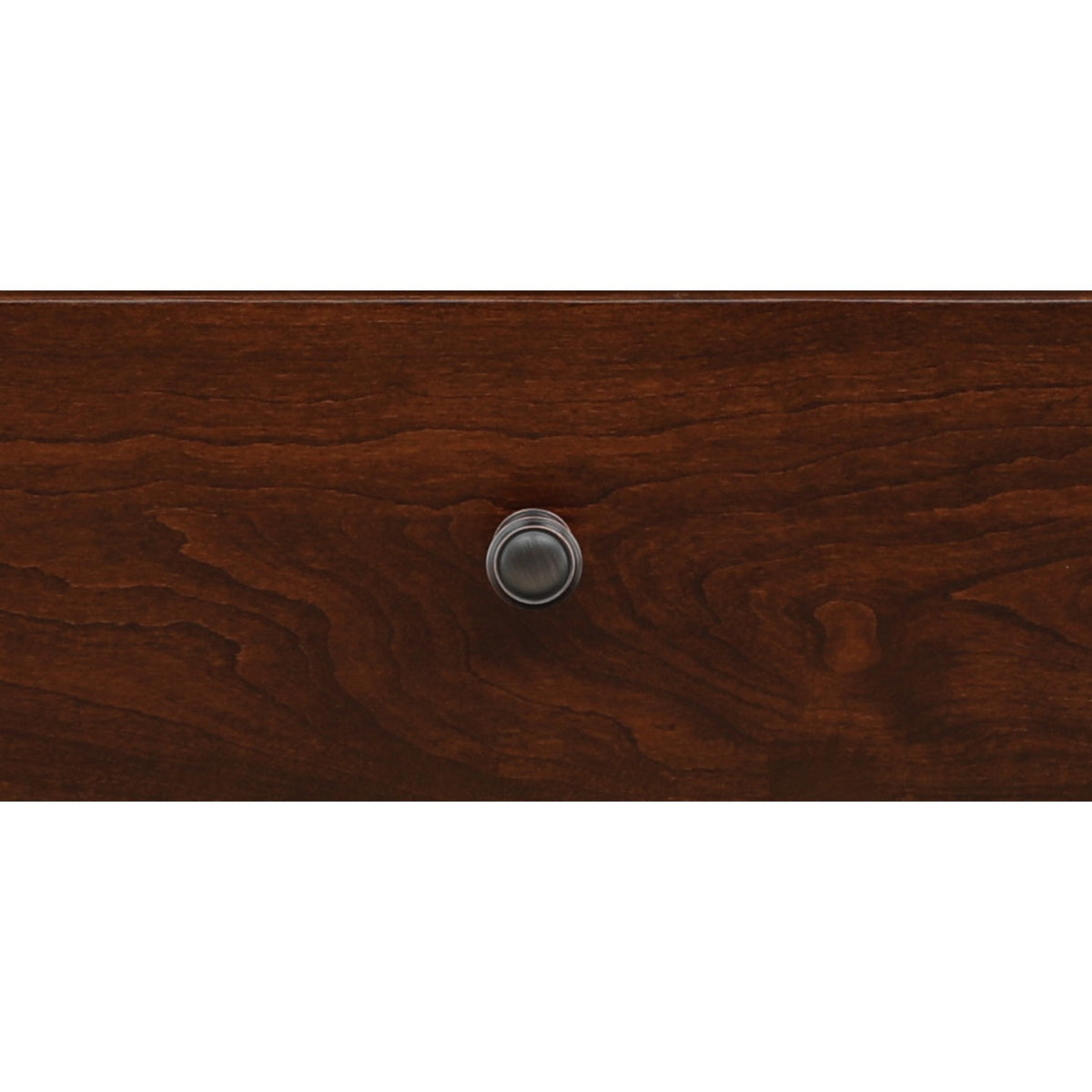 Close-up of round metal drawer pull on brown wood nightstand front