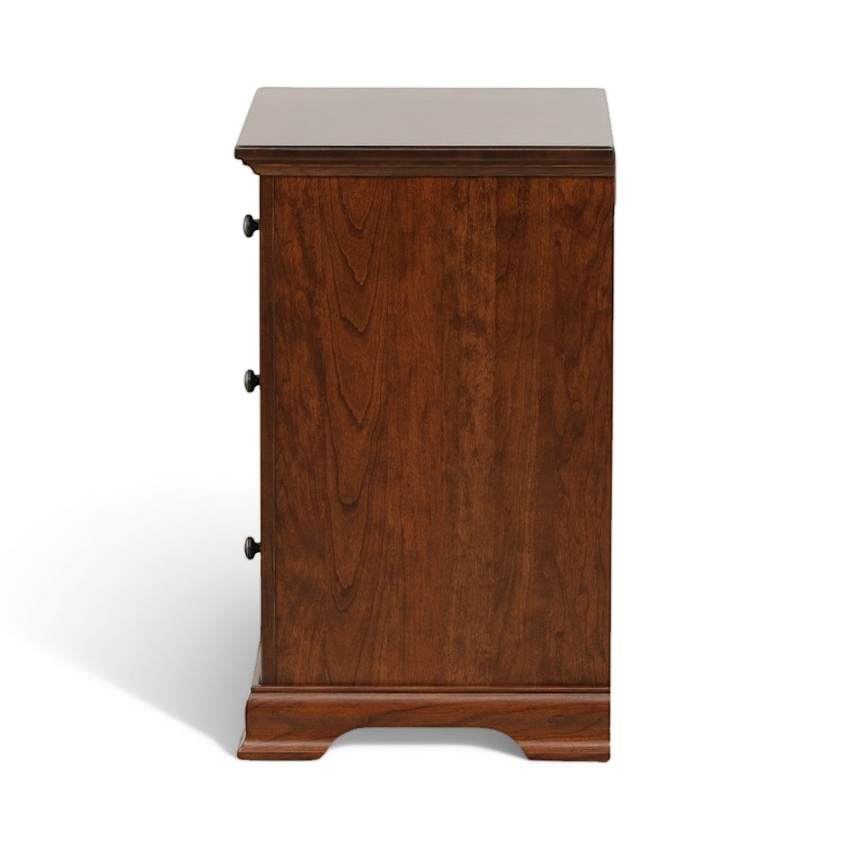 Brown wood nightstand with three drawer fronts and round metal knobs, angled side view
