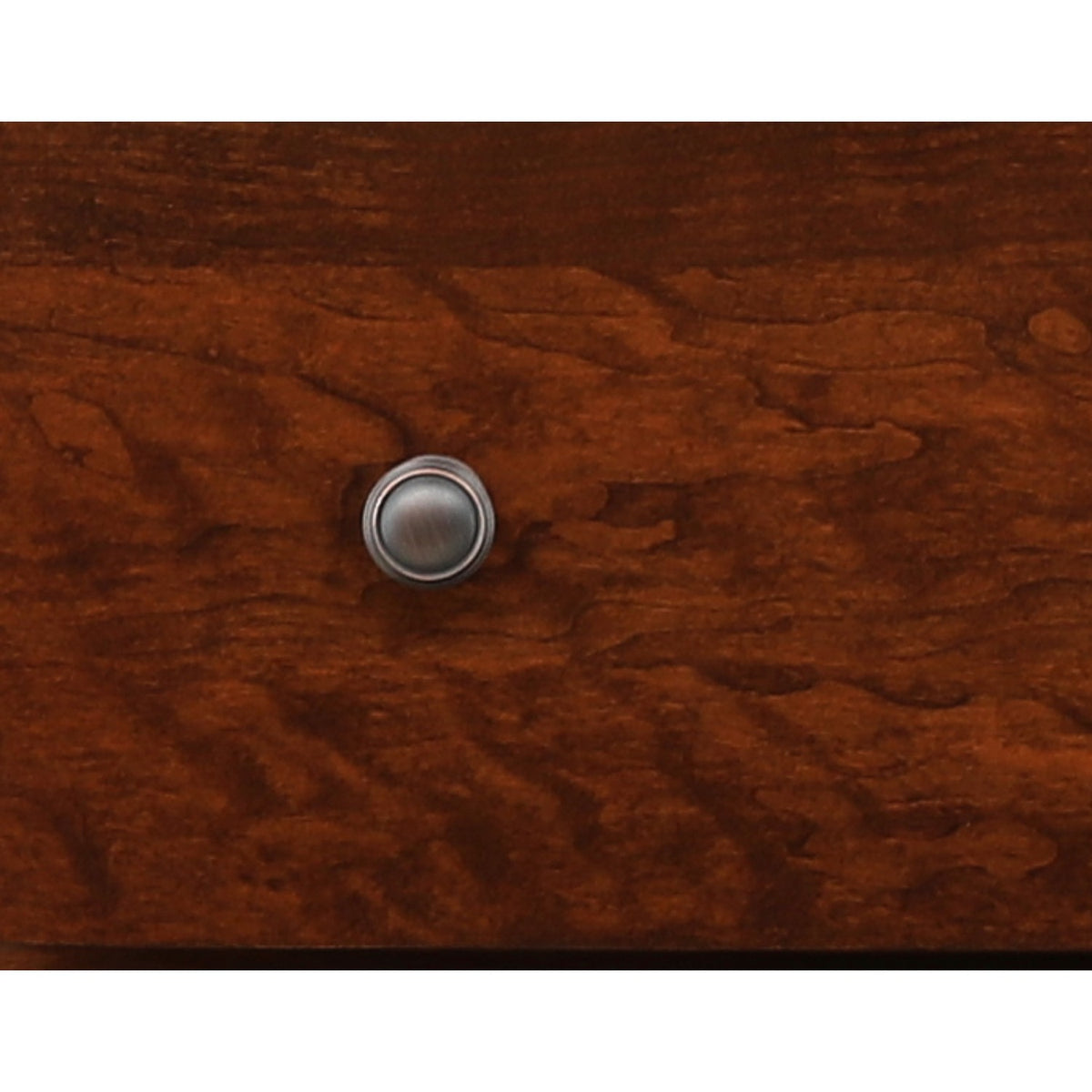 Round metal drawer knob on warm brown wood finish