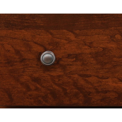 Round metal drawer knob on warm brown wood finish