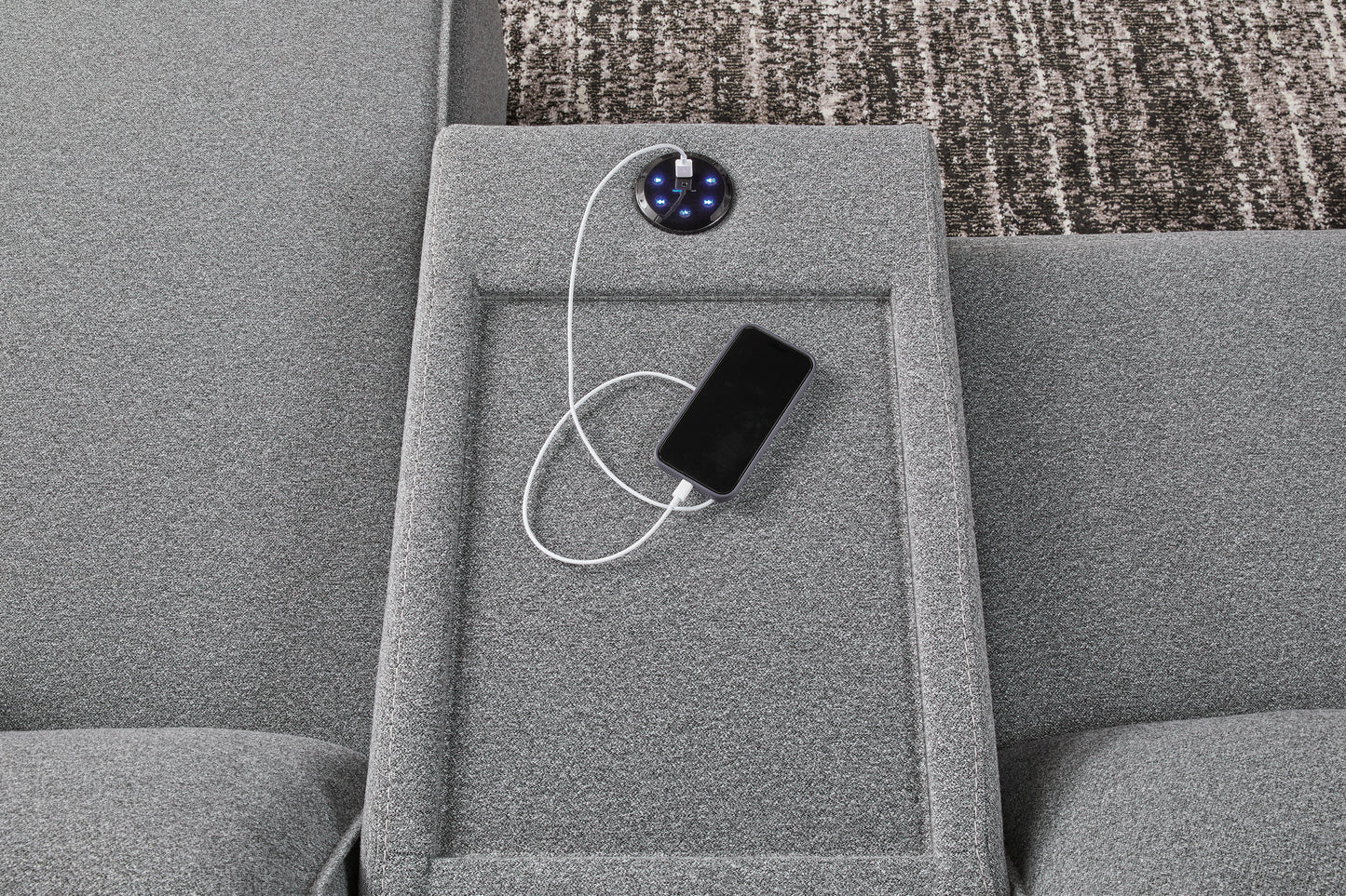 Gray reclining console with built-in charging module and phone on side panel