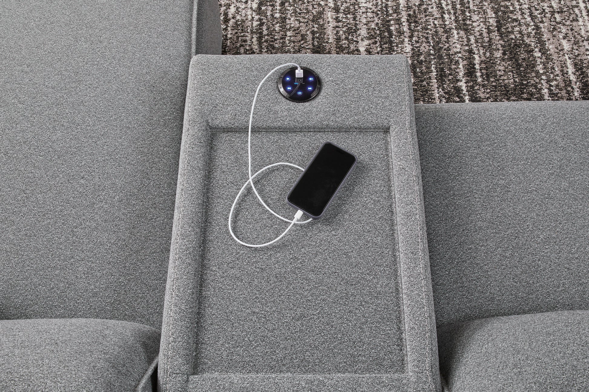 Gray reclining console with built-in charging module and phone on side panel