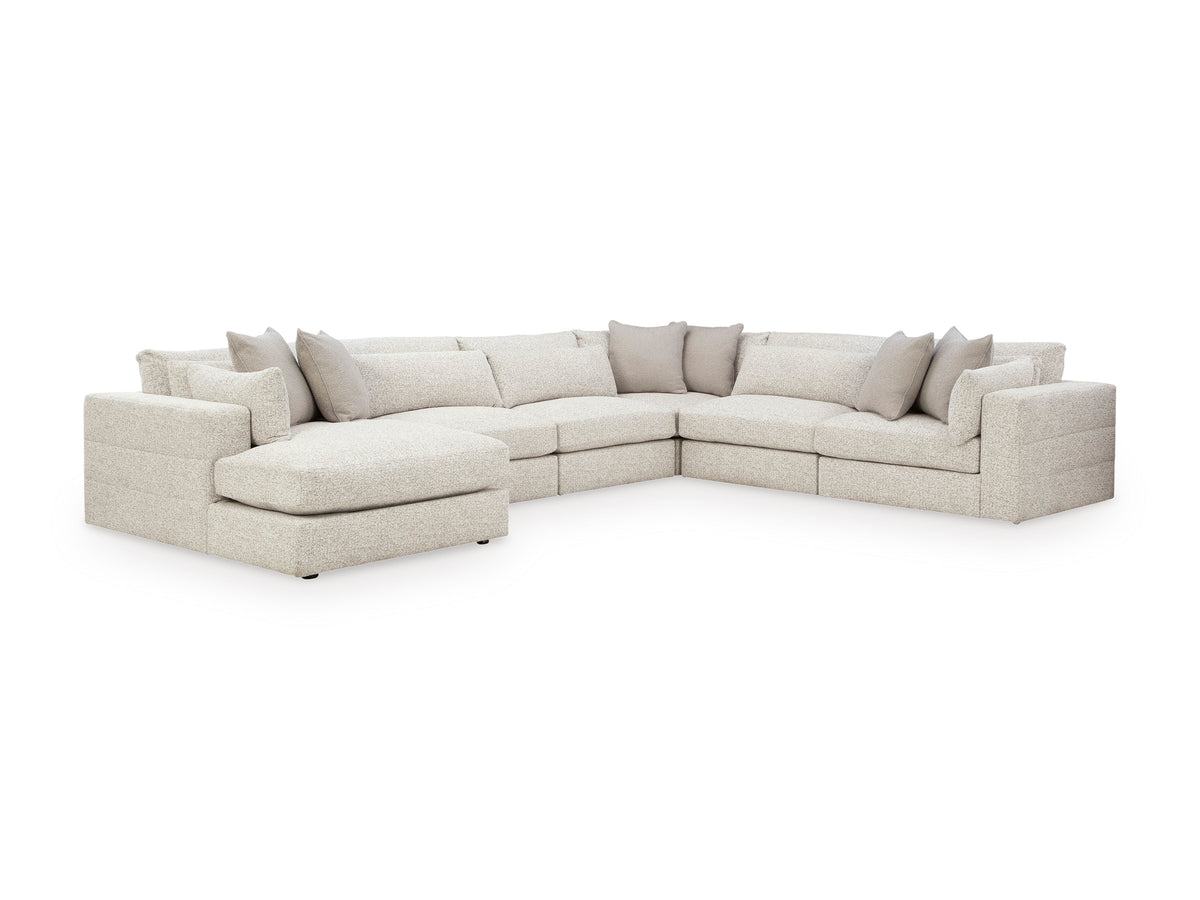 Light beige L-shaped sectional with chaise and multiple throw pillows