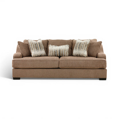 Brown fabric sofa with three seat cushions and three striped accent pillows