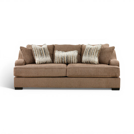 Brown fabric sofa with three seat cushions and three striped accent pillows