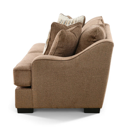Brown upholstered sofa with armrests and layered striped throw pillows