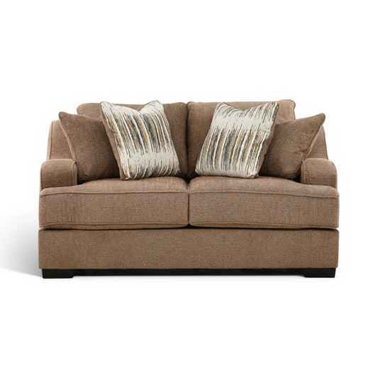 Brown upholstered loveseat with two front accent pillows and tufted back cushions