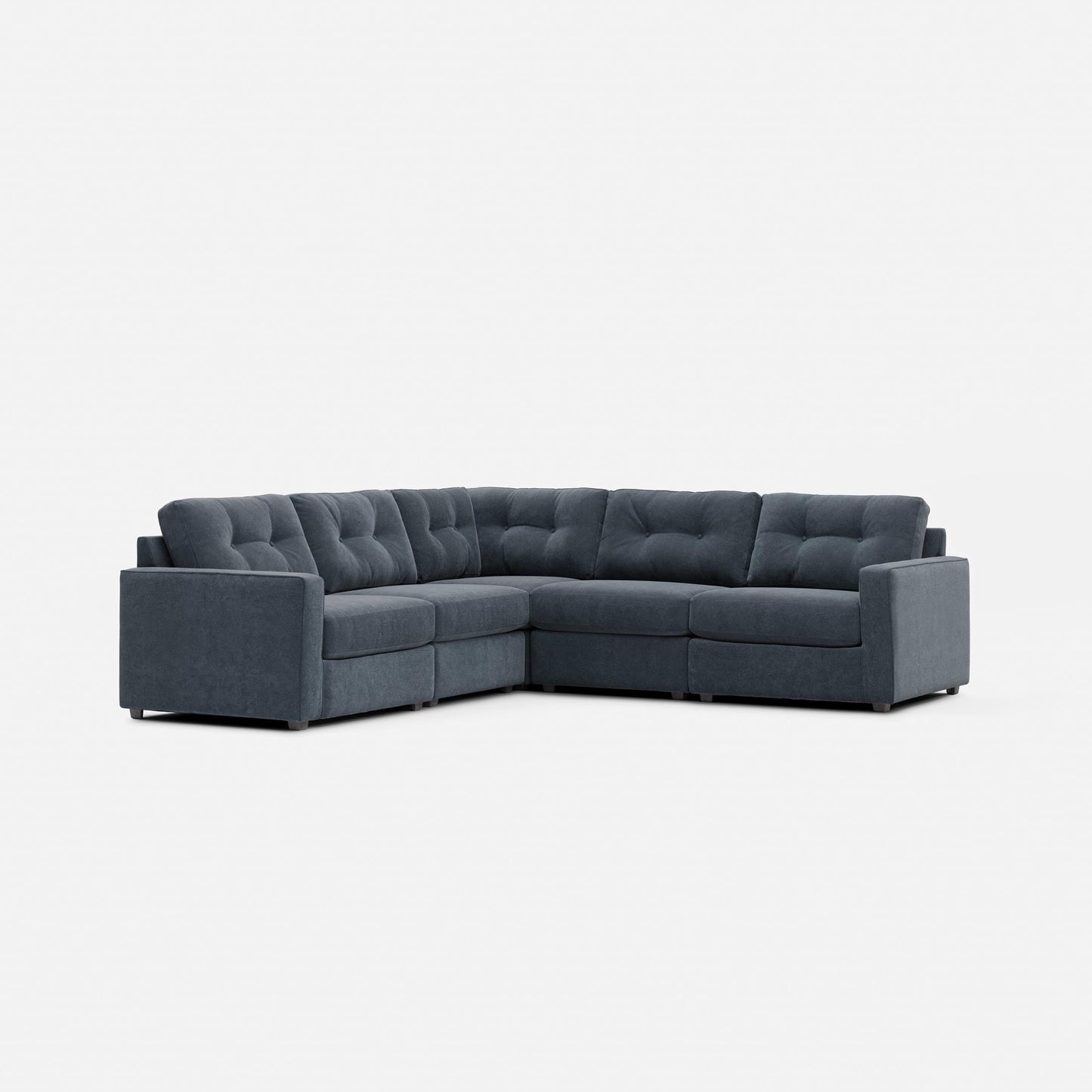 Dark gray modular sectional sofa with tufted back cushions and corner chaise section