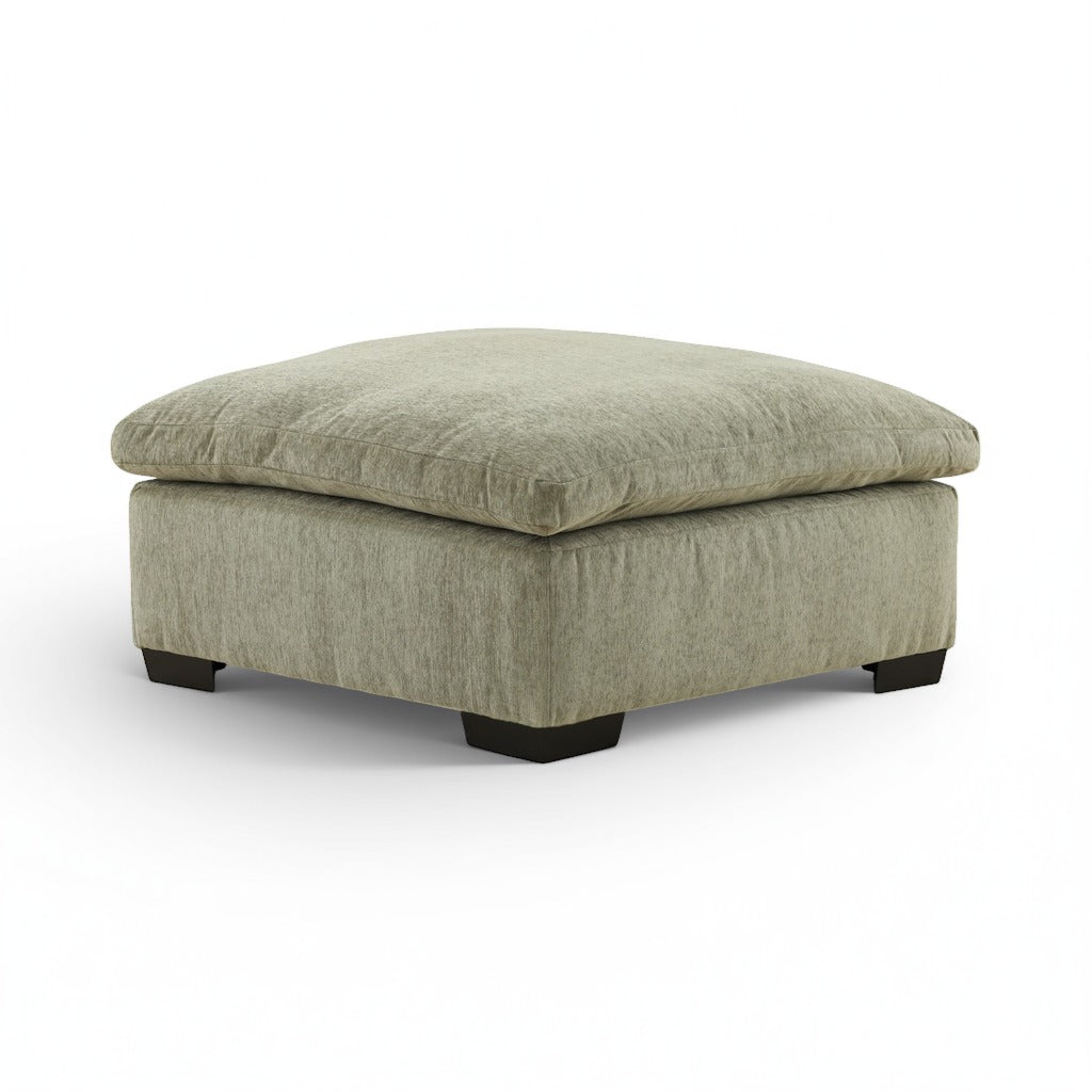 Light green upholstered ottoman with rounded corner profile and black legs