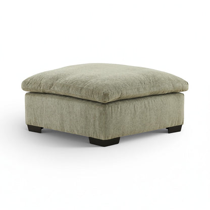 Light green upholstered ottoman with rounded corner profile and black legs