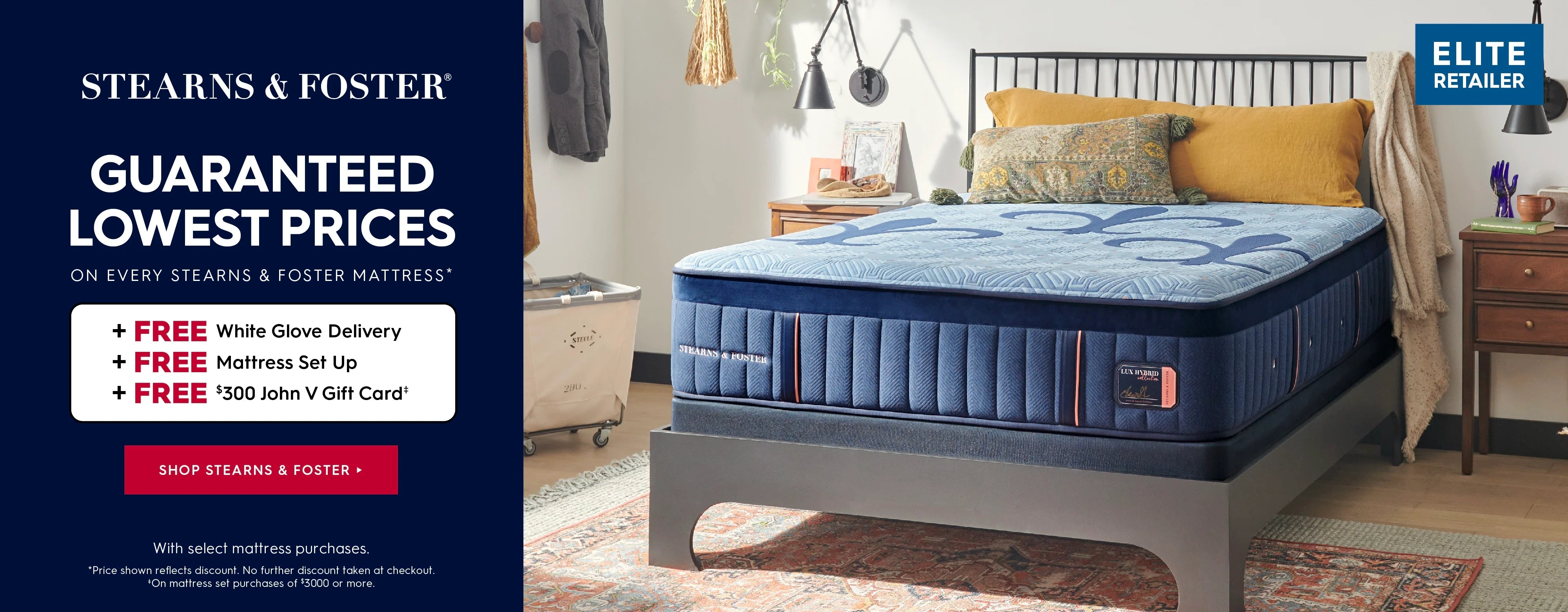 A Stearns & Foster mattress shown in a styled bedroom setting, with a dark navy promotional banner on the left and an Elite Retailer badge in the top right corner. Stearns & Foster. Guaranteed lowest prices on every stearns & foster mattress. Plus, free white glove delivery, free mattress set up, and free $300 John V Gift Card with select mattress purchases. Price shown reflects discount. No further discount taken at checkout. On mattress set purchases of $3000 or more. Shop Stearns & Foster.