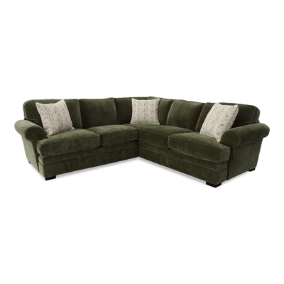 Olive green sectional sofa with corner chaise and four light patterned throw pillows.
