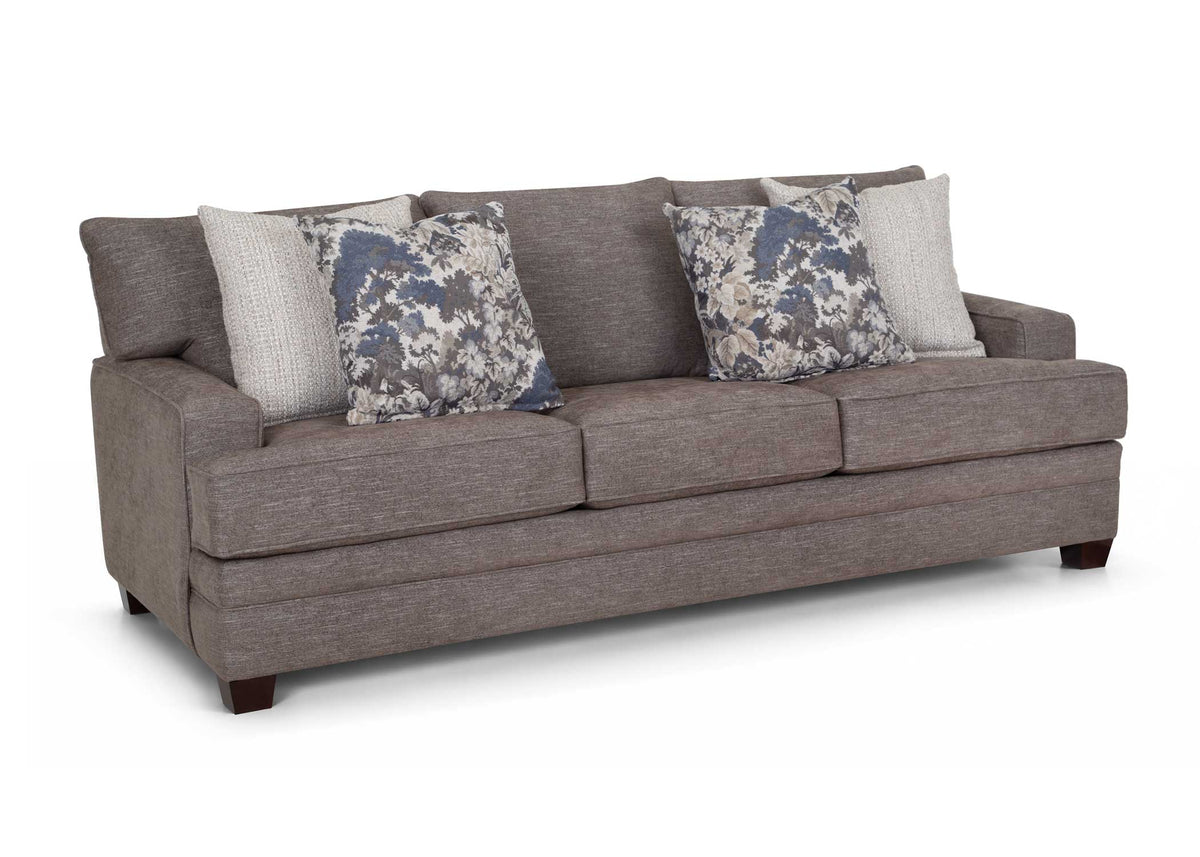 Gray fabric sofa with rolled arms and two floral throw pillows