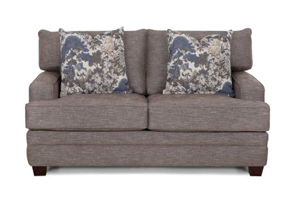 Gray loveseat sofa with rolled arms and two floral accent pillows