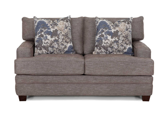 Gray loveseat sofa with rolled arms and two floral accent pillows