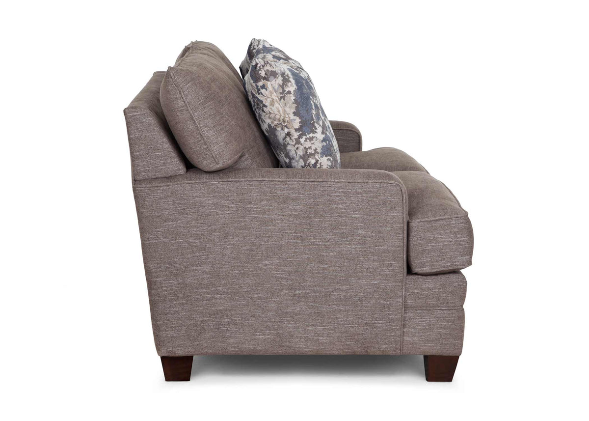 Gray upholstered loveseat with rolled arm and two floral accent throw pillows