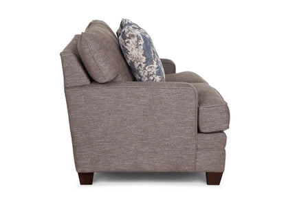 Gray upholstered loveseat with rolled arm and two floral accent throw pillows