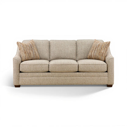 Light beige three-seat sofa with tufted back cushions and two tan striped throw pillows.