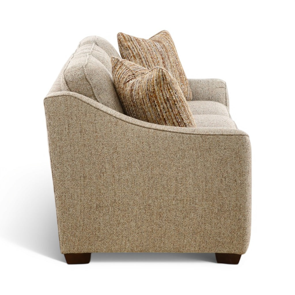Beige accent sofa with two striped pillows, plush back, and exposed dark wood legs.