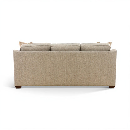 Beige upholstered sofa with straight back and rolled armrests, two included throw pillows.