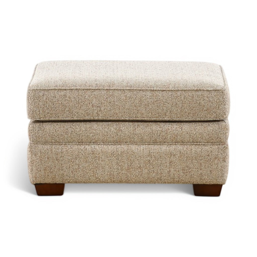 Beige upholstered ottoman with hinged top and front-facing dark wood legs
