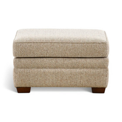 Beige upholstered ottoman with hinged top and front-facing dark wood legs
