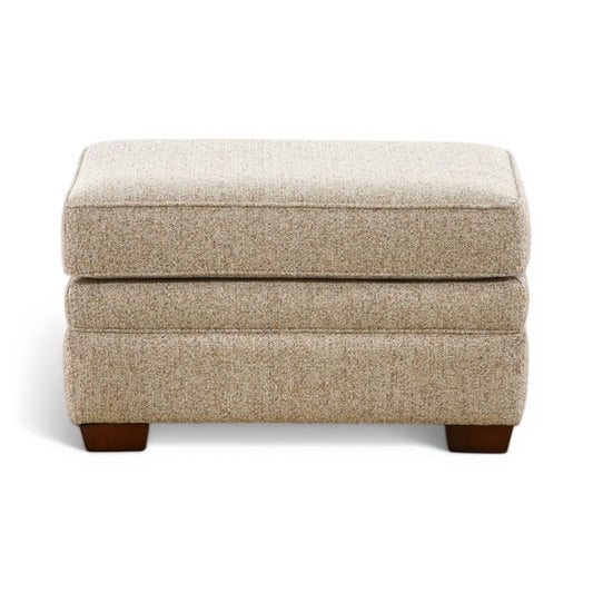 Beige upholstered ottoman with hinged top and front-facing dark wood legs