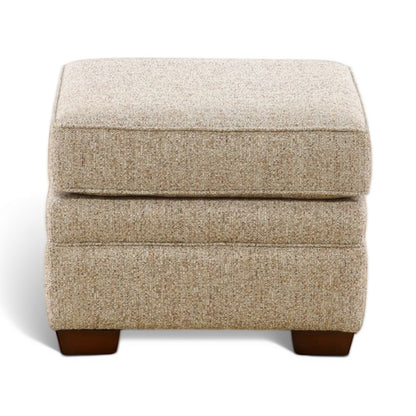 Beige upholstered ottoman with stitched panel detail and dark wood legs