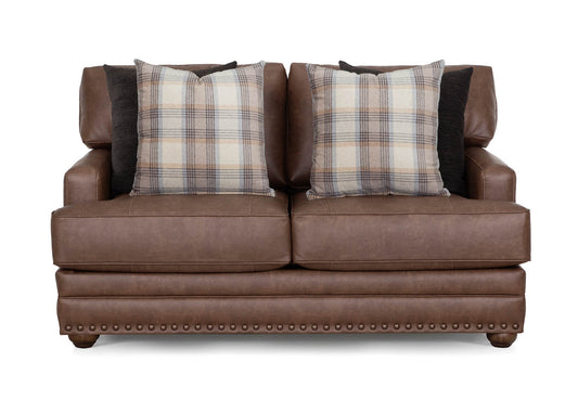 Brown loveseat front view with two plaid throw pillows and studded base trim