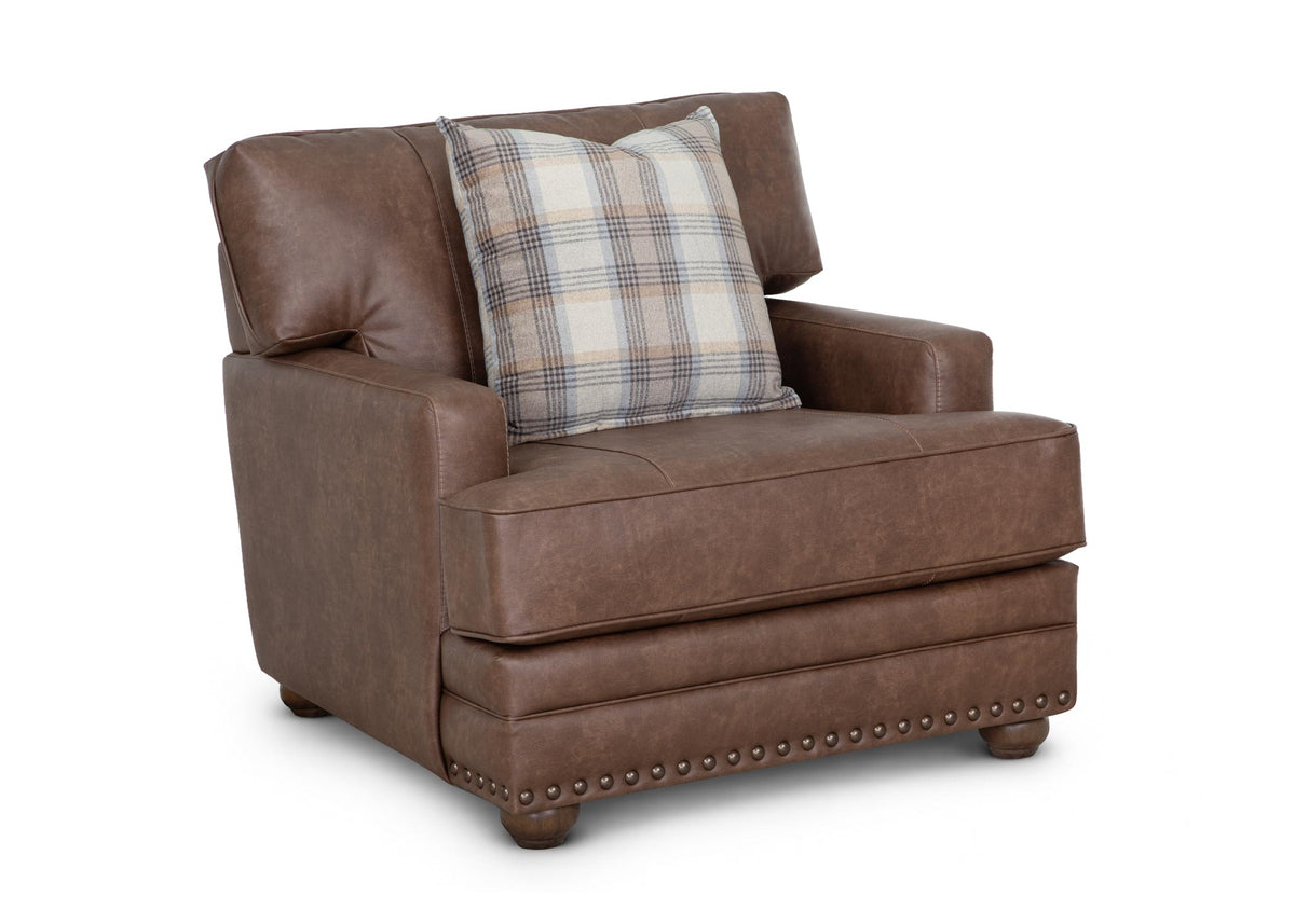 Brown accent chair with plaid throw pillow, padded arms, and nailhead trim front