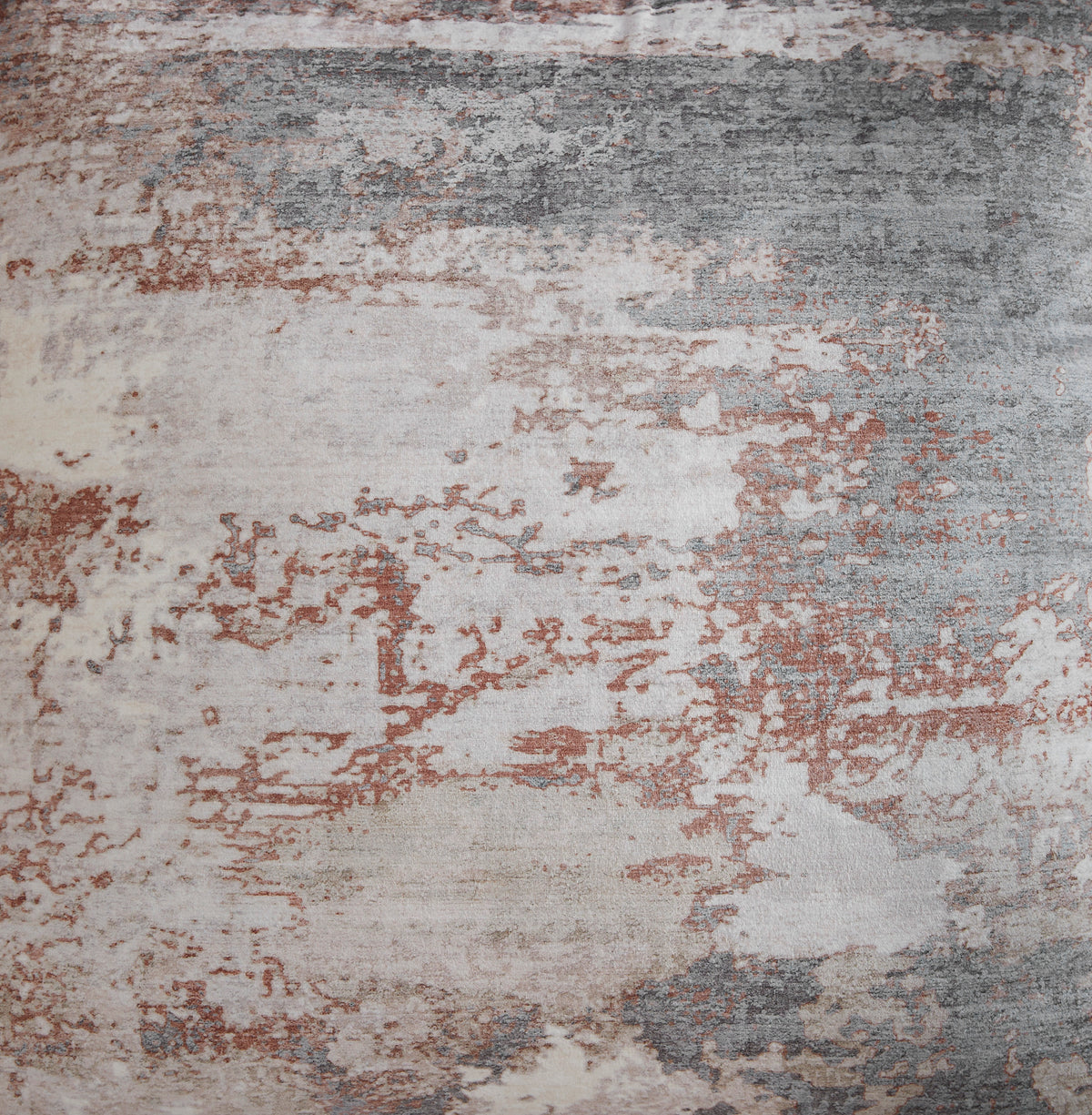 Close-up of distressed abstract pillow fabric in beige, gray, and rust