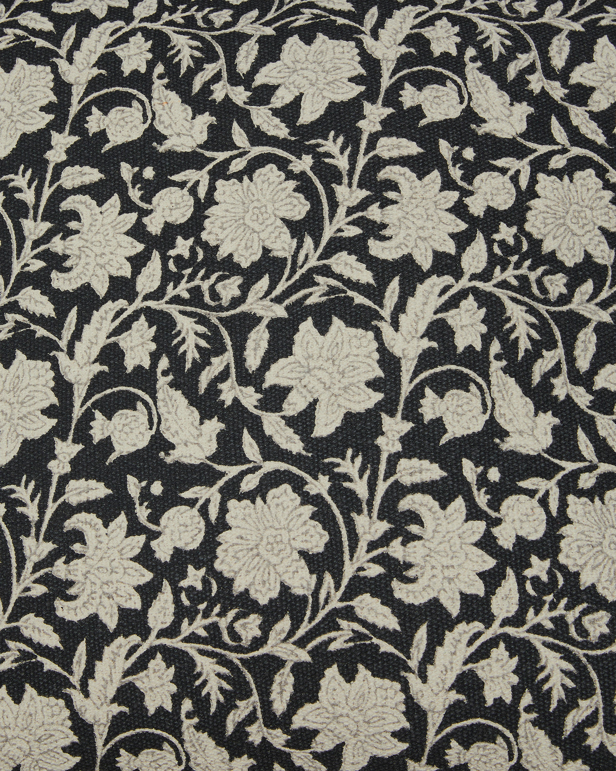 Close-up of black pillow fabric with beige floral vine print texture