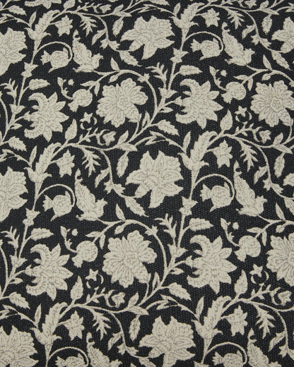 Close-up of black pillow fabric with beige floral vine print texture