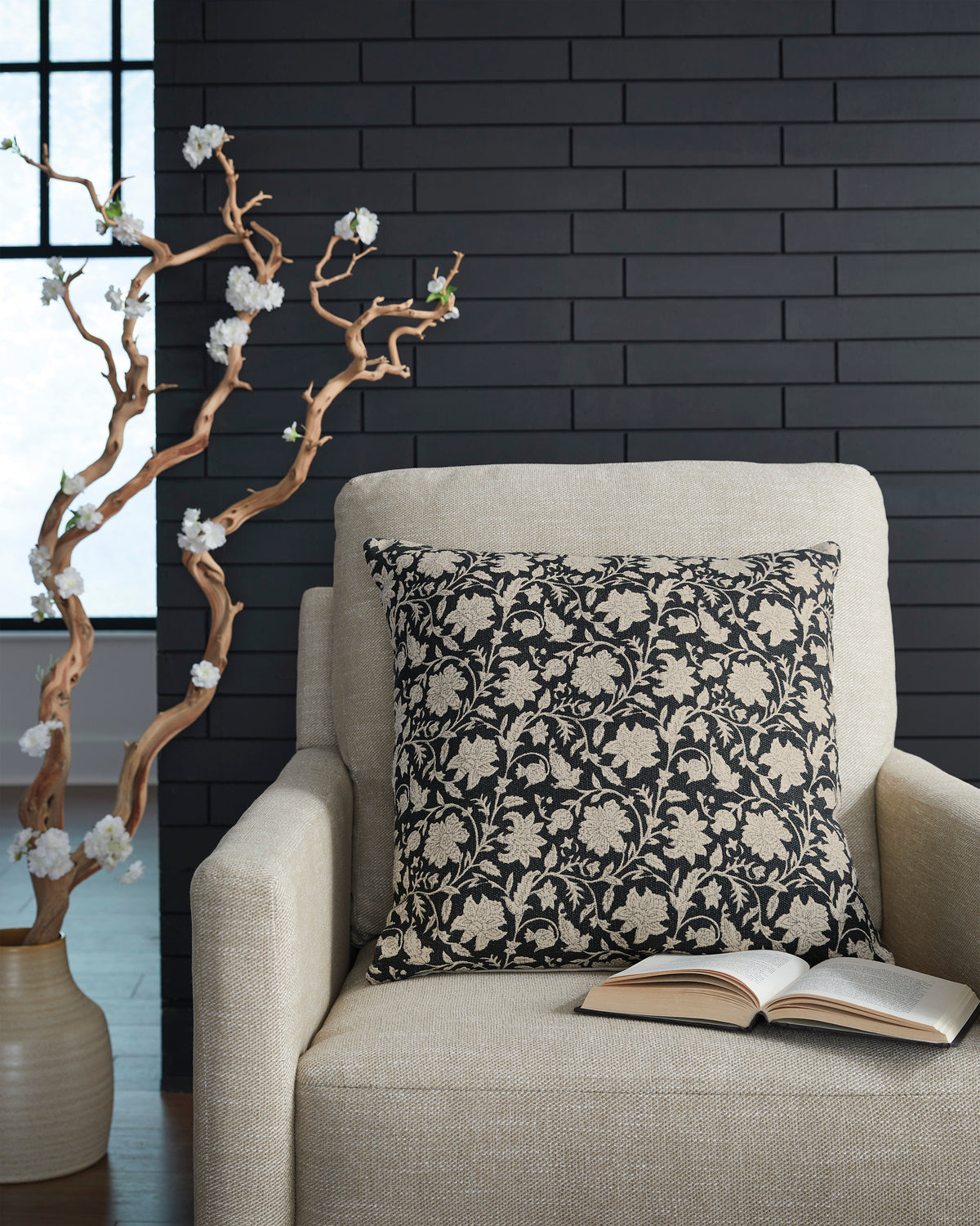 Floral throw pillow with black cover and beige botanical pattern on front