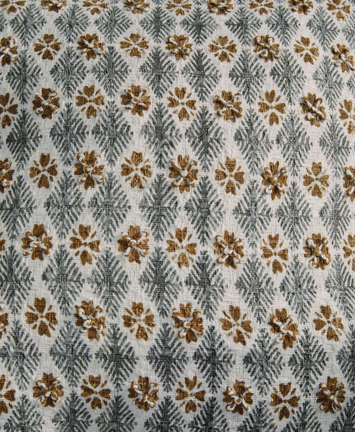 Close-up of light gray fabric with brown and gold floral and geometric pattern